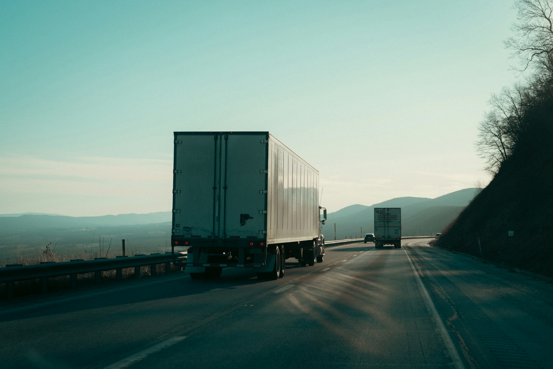 Two semi trucks traveling on a mountain highway